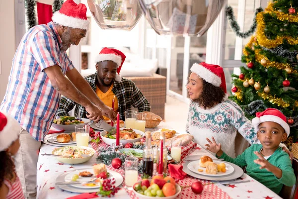 Família Multi Geração Feliz Vestindo Chapéus Papai Noel Tendo Refeição — Fotografia de Stock