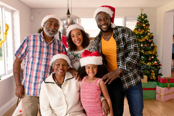 快乐的多代家庭戴着圣诞礼帽 全家在家里共度圣诞节和共度佳节 — 图库照片