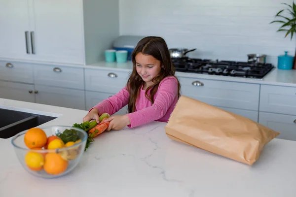 Ευτυχισμένο Καυκάσιο Κορίτσι Ξεπακετάρει Ψώνια Στην Κουζίνα Παιδική Ηλικία Αναψυχή — Φωτογραφία Αρχείου