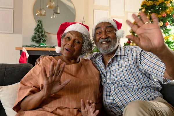 快乐的非洲裔美国夫妇戴着圣诞期间有视频通话的圣诞礼帽 圣诞节 节日和家庭通信技术 — 图库照片