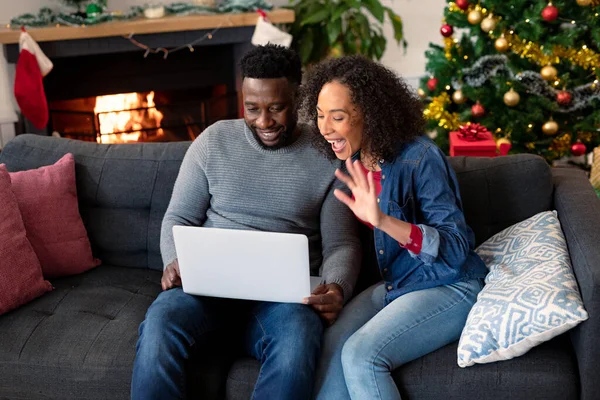 ラップトップでビデオ通話をしている幸せなアフリカ系アメリカ人のカップル 背景にクリスマスの装飾 クリスマスやお祭りや通信技術は — ストック写真