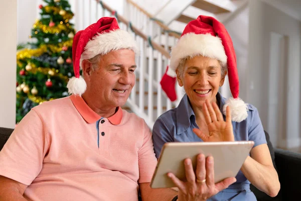 Szczęśliwa Para Seniorów Białym Kapeluszu Używająca Tabletu Wideokonferencja Czasie Świąt — Zdjęcie stockowe