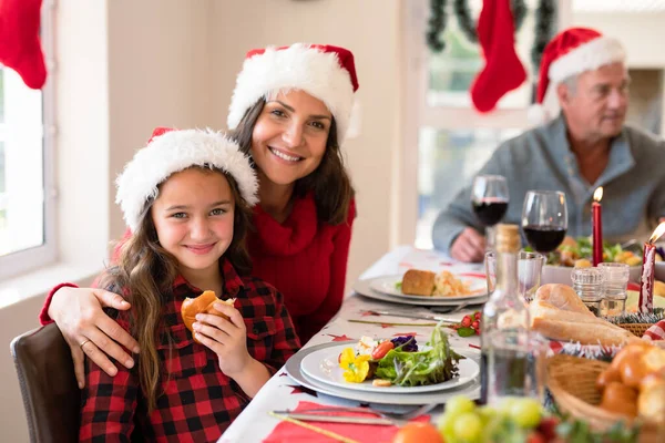 快乐的高加索母亲和女儿戴着桑塔帽 在圣诞节的时候看着镜头 全家在家里共度圣诞节和共度佳节 — 图库照片
