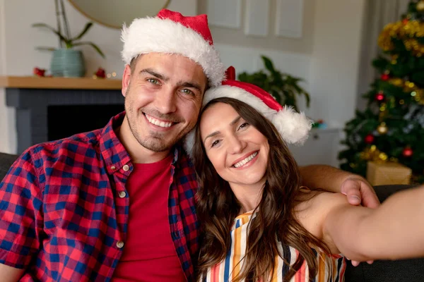 Feliz Pareja Caucásica Vistiendo Sombreros Santa Tomando Selfie Decoraciones Navidad — Foto de Stock