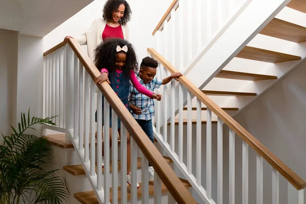幸せなアフリカ系アメリカ人の母親と子供たちが階下を歩く 家族で楽しみながら — ストック写真