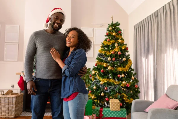 幸福的非洲裔美国夫妇拥抱在一起 背景上的圣诞装饰品 全家在家里共度圣诞节和共度佳节 — 图库照片