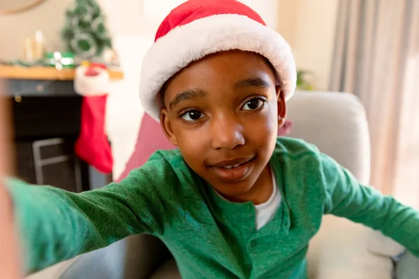 アフリカ系アメリカ人の少年はサンタの帽子をかぶってクリスマスに自撮りをする クリスマスやお祭りや通信技術は — ストック写真