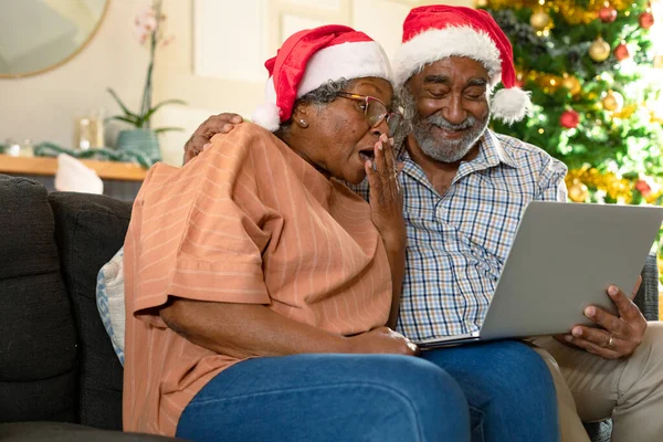 Sorprendida Pareja Afroamericana Con Sombreros Santa Claus Haciendo Videollamadas Navidad — Foto de Stock