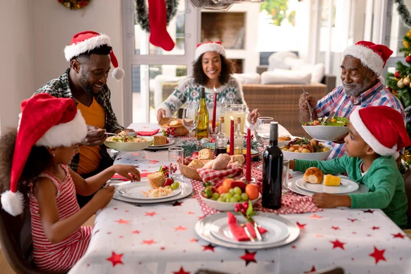 Feliz Familia Multi Generación Usando Sombreros Santa Teniendo Comida Navidad —  Fotos de Stock