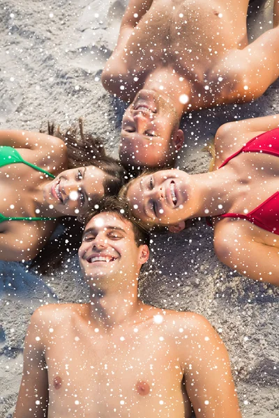 Friends lying against snow falling — Stock Photo, Image