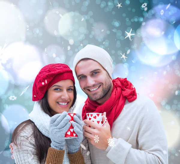 Casal de inverno segurando canecas — Fotografia de Stock