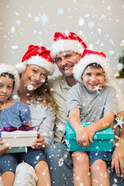 Família em Natal chapéu segurando presentes — Fotografia de Stock