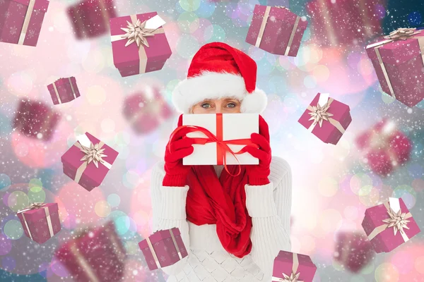 Imagen compuesta de mujer festiva sosteniendo regalo — Foto de Stock