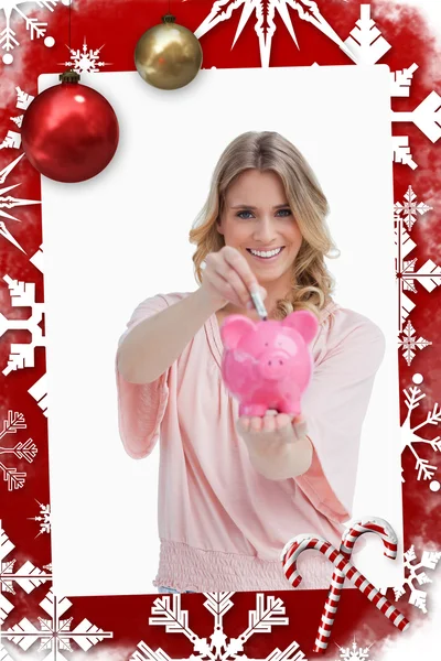 Smiling woman putting money into a piggy bank — Stock Photo, Image