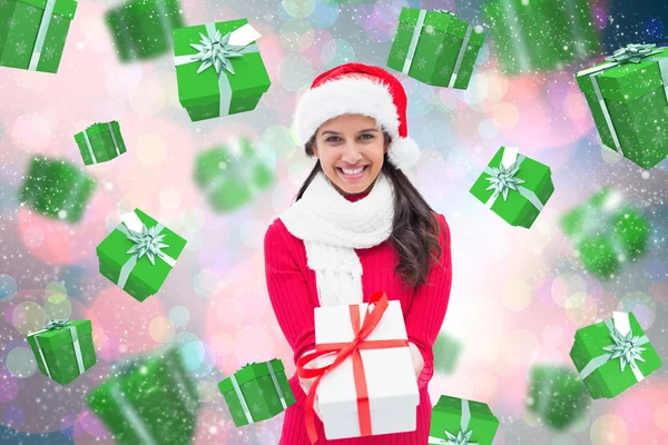 Composite image of festive brunette holding gift — Stock Photo, Image