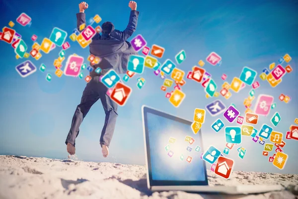 Businessman jumping on beach — Stock Photo, Image