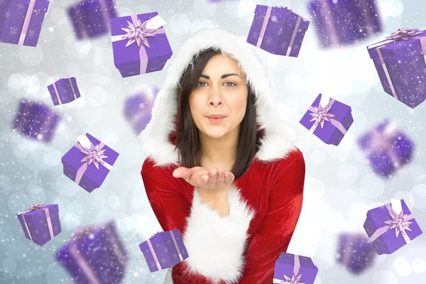 Composite image of pretty girl in santa outfit blowing — Stock Photo, Image