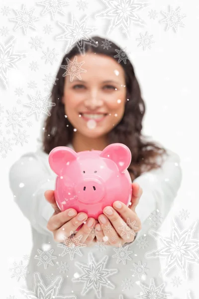 Brunette tonen een piggy bank — Stockfoto