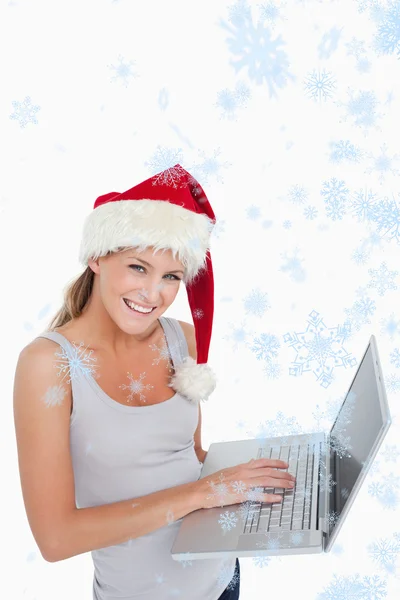 Kadın bir dizüstü bilgisayar kullanarak bir Noel şapka — Stok fotoğraf