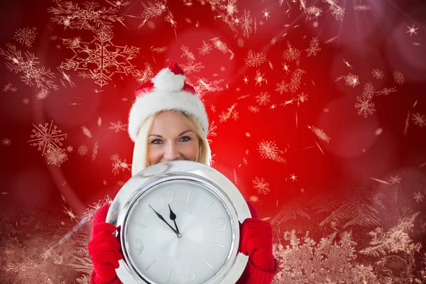 Happy festive blonde with clock — Stock Photo, Image