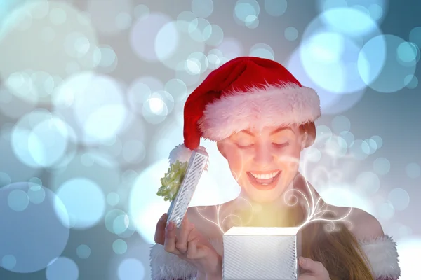 Sexy Mädchen im Weihnachtsmannkostüm öffnet ein Geschenk — Stockfoto
