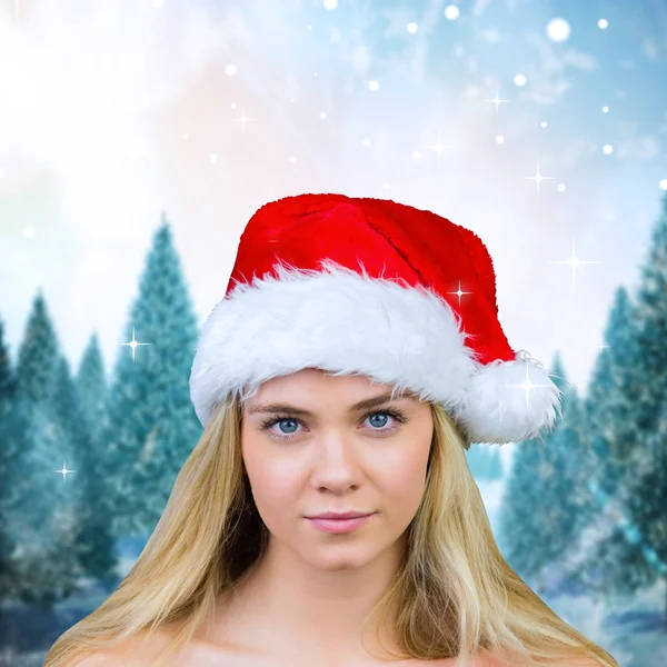 Composite image of blonde with bare shoulders in santa hat — Stock Photo, Image