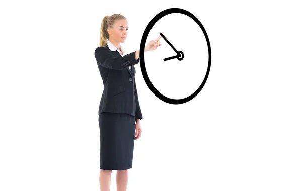 Businesswoman pointing to black clock — Stock Photo, Image
