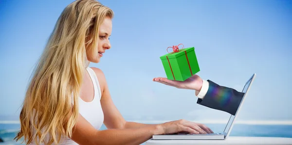 Bionda usando il suo computer portatile in spiaggia — Foto Stock