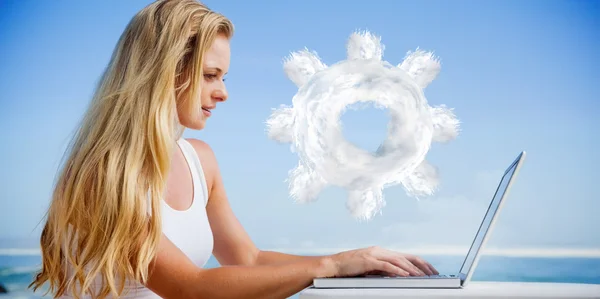 Bionda usando il suo computer portatile in spiaggia — Foto Stock