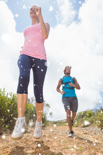 Fit attractive couple jogging down mountain trail — Stock Photo, Image