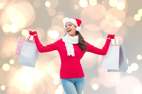 Imagen compuesta de morena festiva sosteniendo bolsas de compras — Foto de Stock