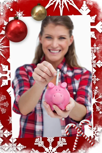 Retrato de uma mulher colocando uma nota um banco porquinho — Fotografia de Stock