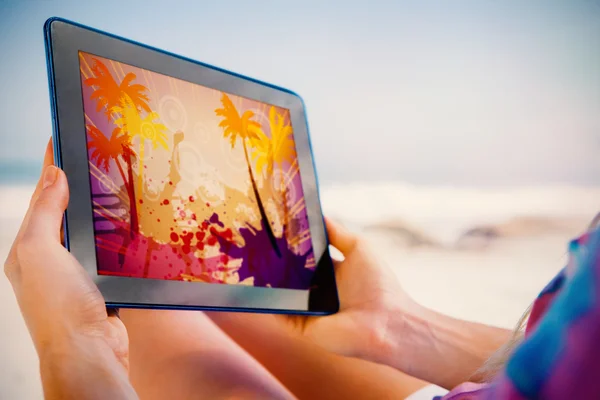Žena sedí na pláži a použití tabletu — Stock fotografie