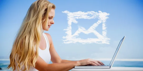 Blondine benutzt ihren Laptop am Strand — Stockfoto