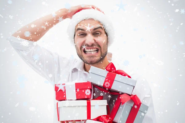 Stressed festive man holding gifts — Stock Photo, Image