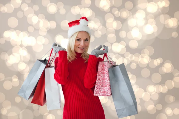 Imagem composta de loira festiva feliz com sacos de compras — Fotografia de Stock