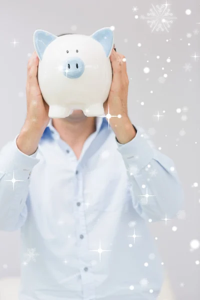Man holding piggy bank in front of his face — Stock Photo, Image