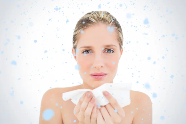 Blonde woman sneezing against snow falling — Stock Photo, Image