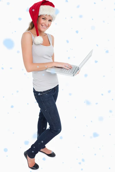 Woman with a christmas hat using a laptop — Stock Photo, Image