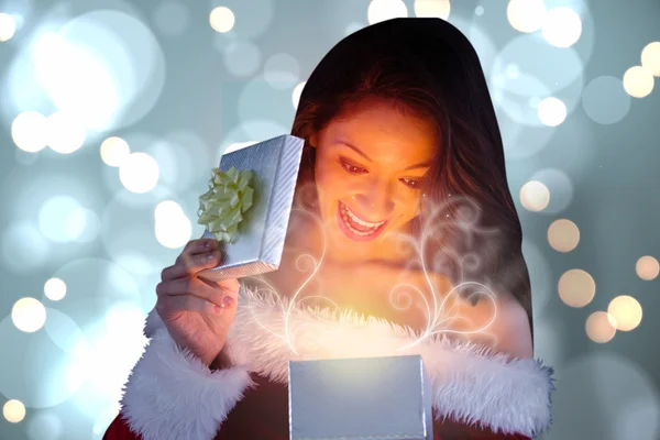 Composite image of sexy santa girl opening gift — Stock Photo, Image