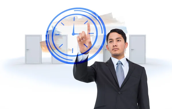 Serious asian businessman pointing to clock — Stock Photo, Image