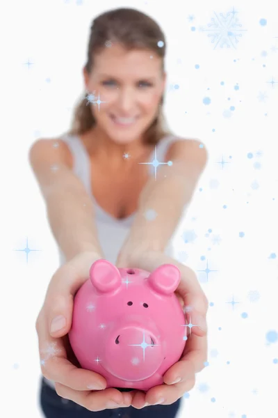 Mooie vrouw toont een piggy — Stockfoto