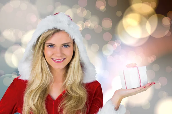 Sammansatt bild av söt flicka i Santa outfit innehav gåva — Stockfoto