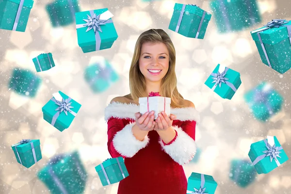 Composite image of pretty girl in santa outfit holding gift Stock Picture