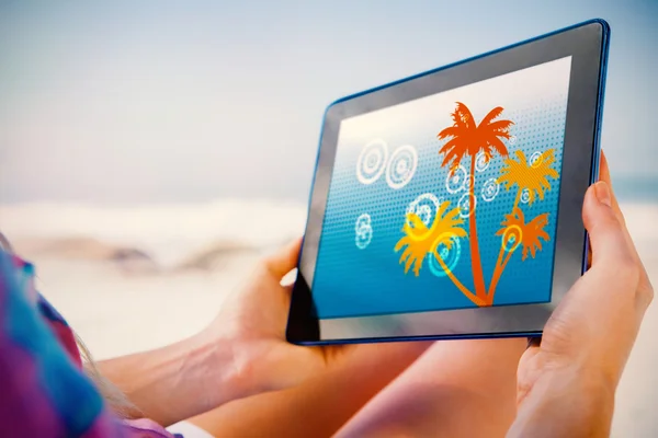 Frau sitzt mit Tablet am Strand — Stockfoto