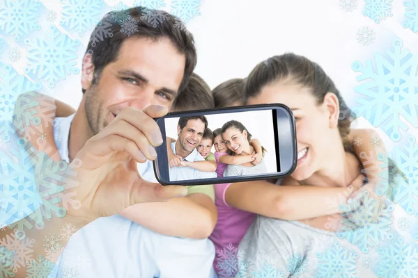 Улыбающаяся молодая семья смотрит в камеру — стоковое фото