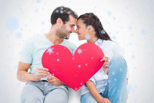 Couple sitting holding red heart — Stock Photo, Image