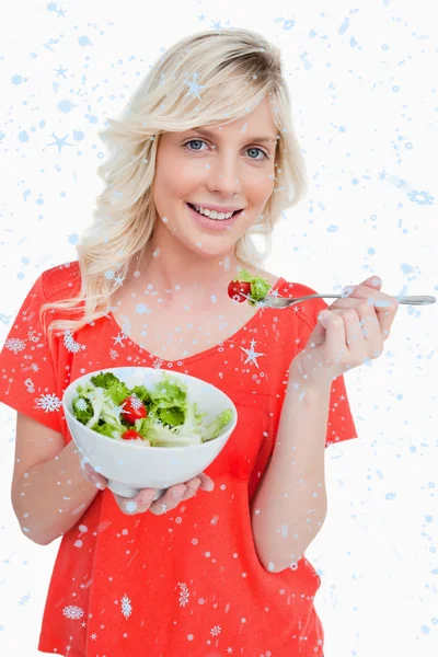 Jeune femme souriante manger une salade fraîche — Photo