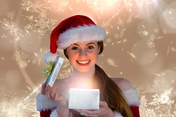 Girl in santa costume opening gift — Stock Photo, Image
