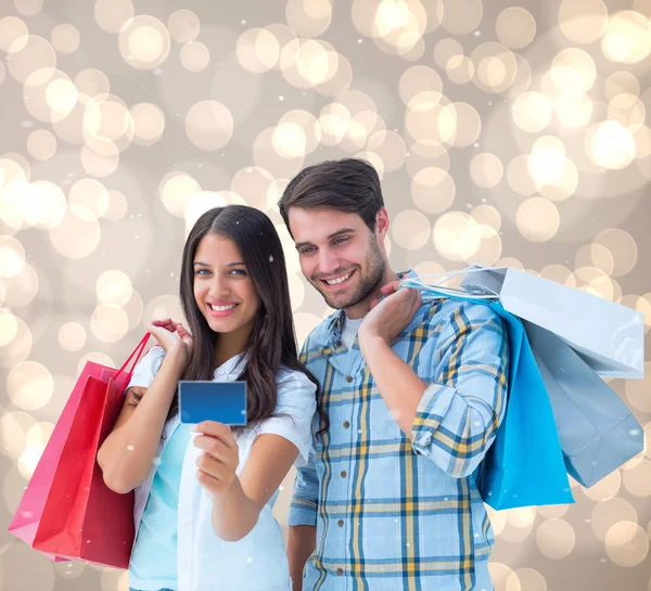 Pareja con bolsas de compras y tarjeta de crédito — Foto de Stock